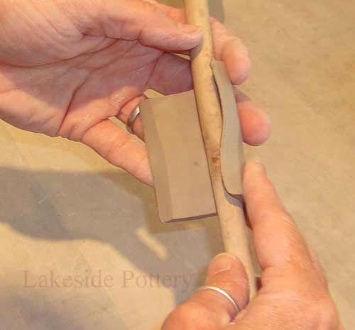 use wooden spoon to roll clay into shape