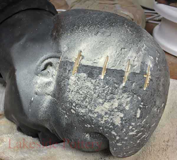 brass pegs inserted in deacon jones cracked bust head