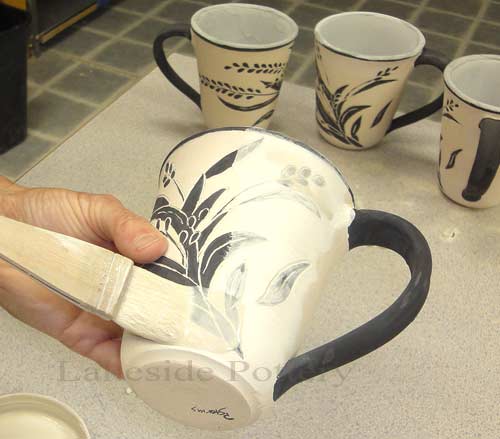 applying clear glaze gently on bisque