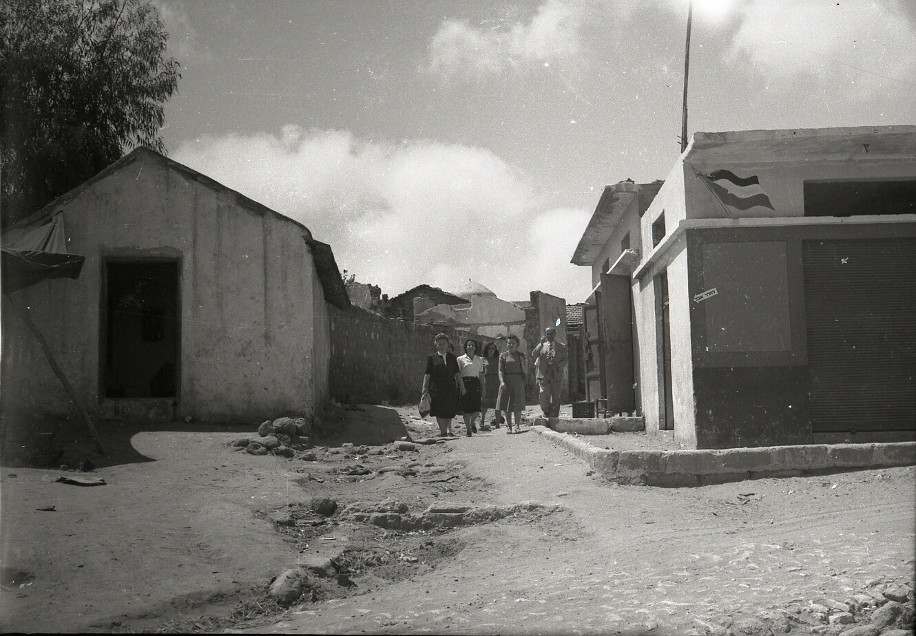 Jewish immigrants walking through the depopulated Palestinian village of Salama in 1948