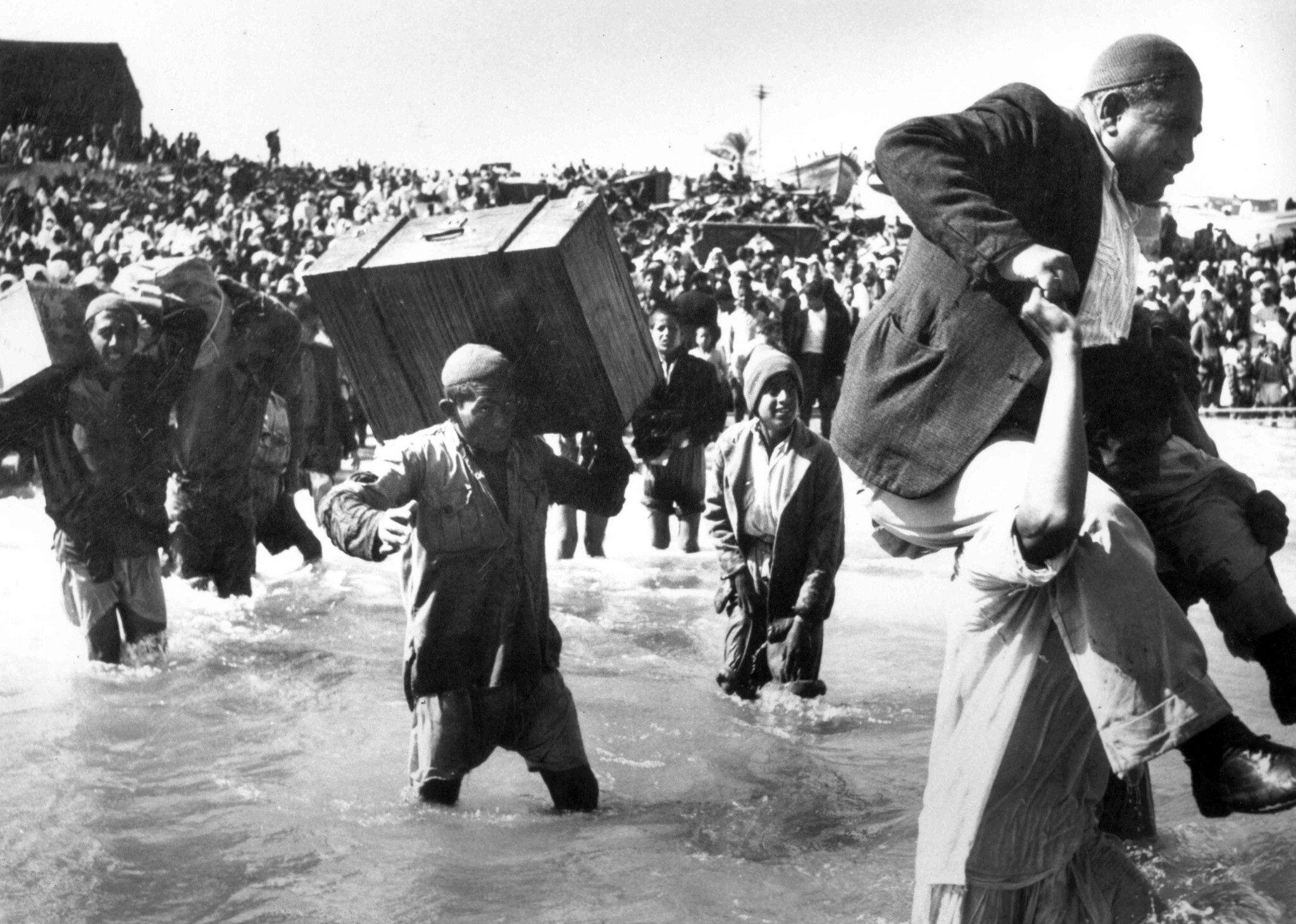 Palestinian residents fleeing Akko with children and belongings during the 1948 war